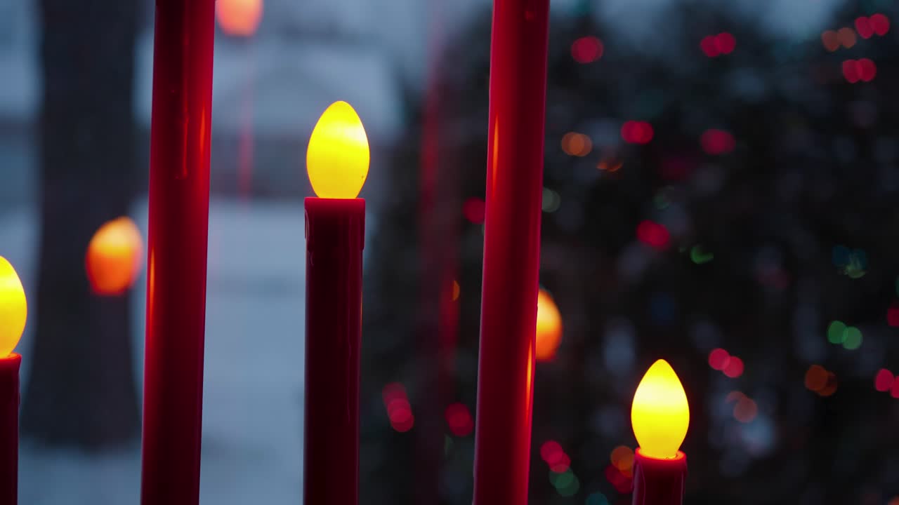 Candle Led Lamps and snow falling on Christmas eve, slomo shallow focus.