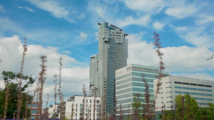 Una vista dal basso del grattacielo Sea Towers e della moderna architettura commerciale a Gdynia, Polonia, sotto un cielo blu. Adatto per contenuti sullo sviluppo urbano e immobiliare.