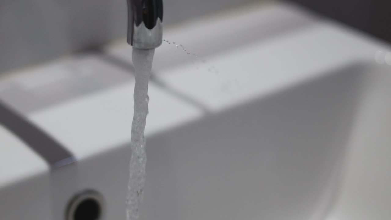 agua que fluye de un grifo a una cuenca