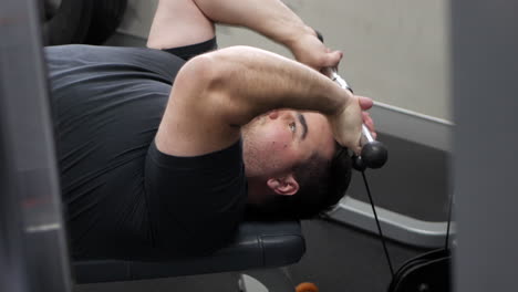 young male using machine weights to train