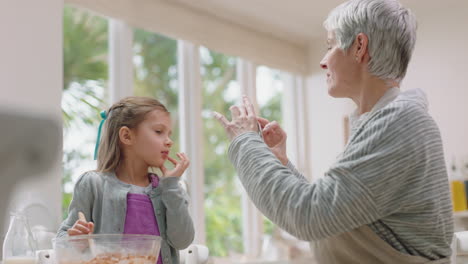 happy-grandmother-using-smartphone-taking-photo-of-cute-grandaughter-in-kitchen-mixing-ingredients-for-baking-tasting-chocolate-sauce-granny-sharing-weekend-with-grandchild-on-social-media