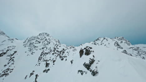 snow-covered mountains in tromsø under a cloudy winter sky, peaceful and cold