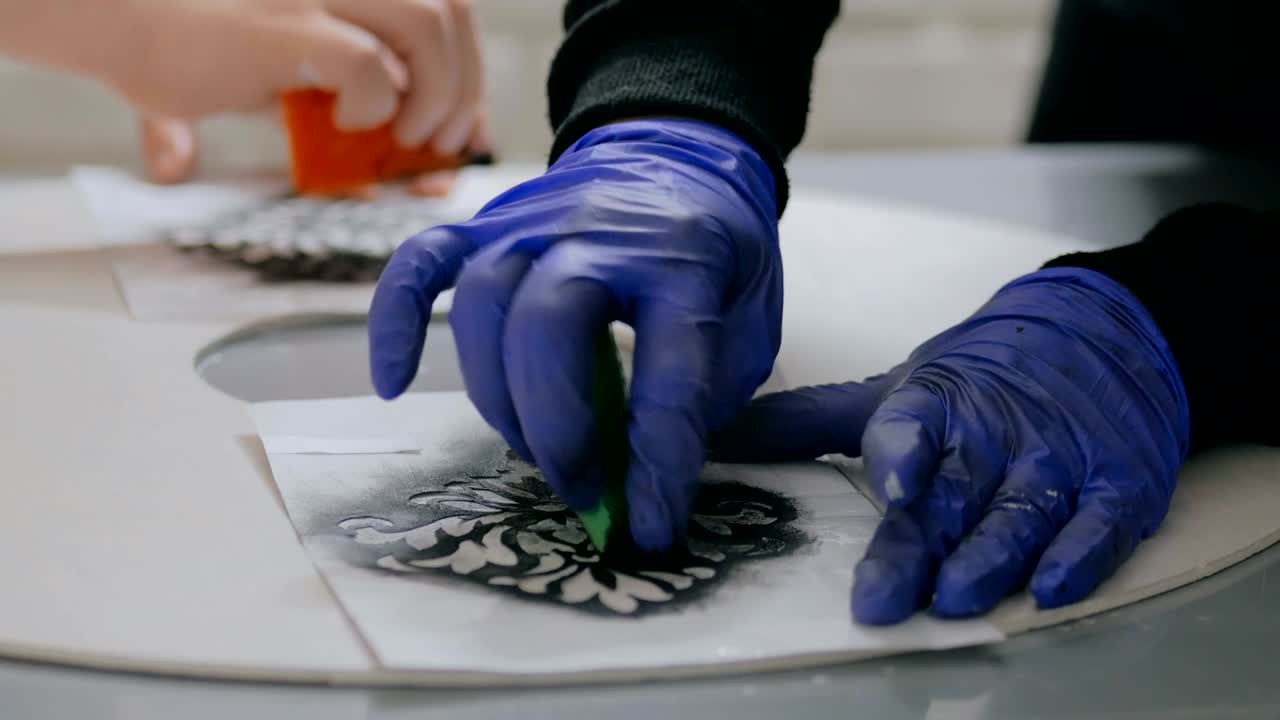 руки женщины рисуют на деревянном круге