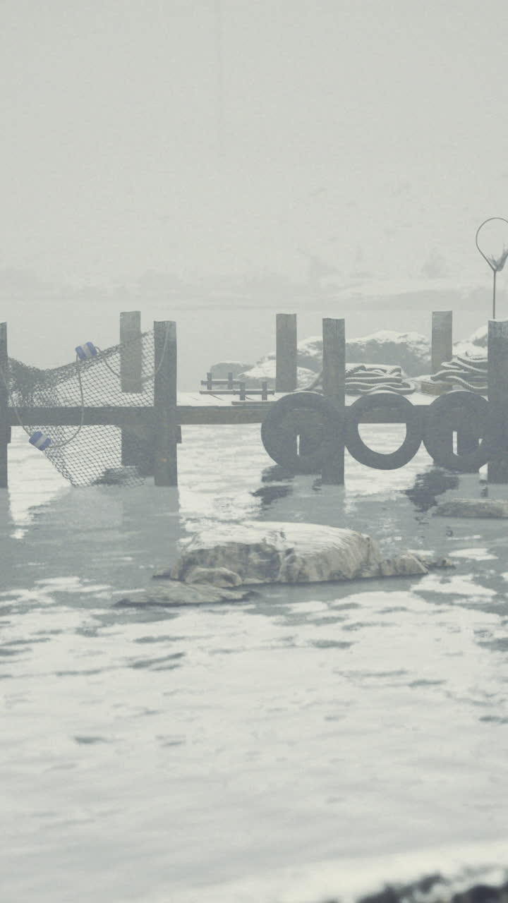 Winter landscape with a foggy pier and calm water reflecting snow