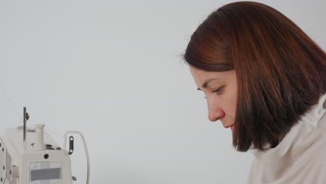 costumer setting up sewing machine while stitching material with focused attention, showcasing precise control, and skilled craftsmanship in bright workspace for efficient garment creation