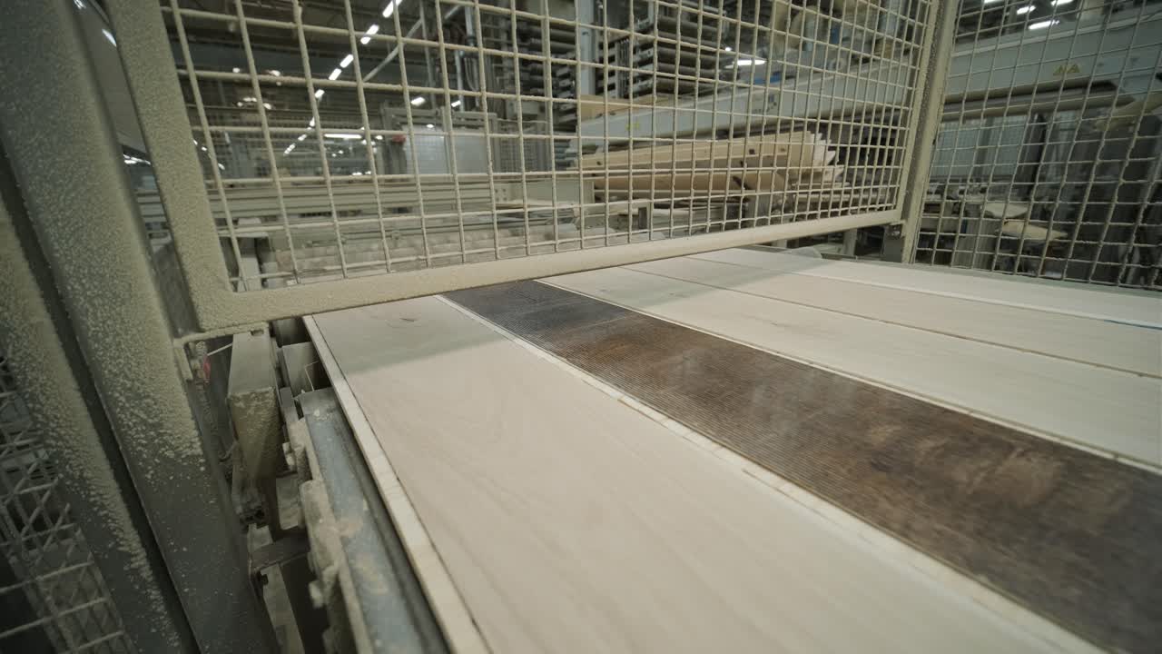 Assi di legno che si muovono su un nastro trasportatore automatizzato in fabbrica.