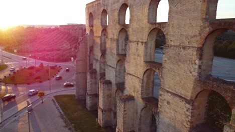 drone shot flying away and revealing an aqueduct in elvas, portugal with real lens flare