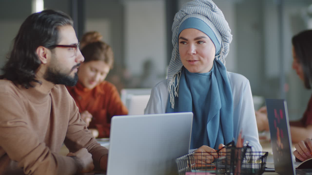 무슬림 여성들이 남성 동료와 사무실에서 만나고 있습니다.