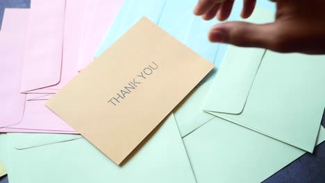 hand holding a thank you note with envelopes