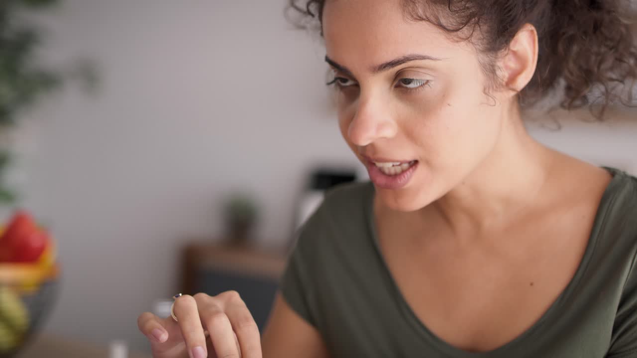 Video con ripresa dal basso verso l'alto di una donna felice che si fa la manicure a casa.