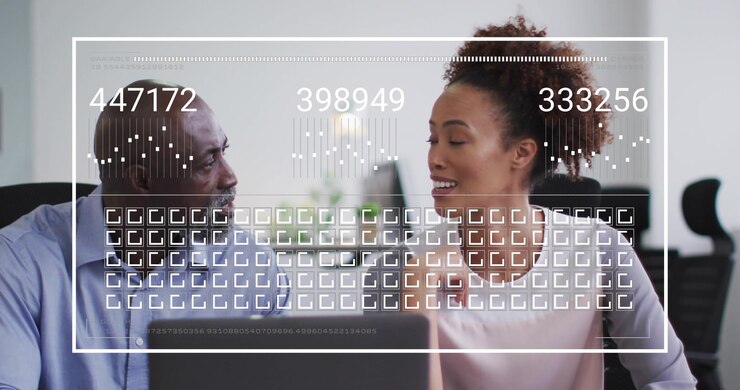 Woman tapping laptop initiating data overlay showing line graphs for business, colleague nodding