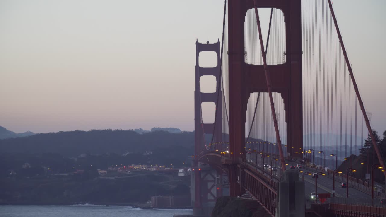 tiro largo estático del tráfico que pasa por el puente golden gate antes del amanecer