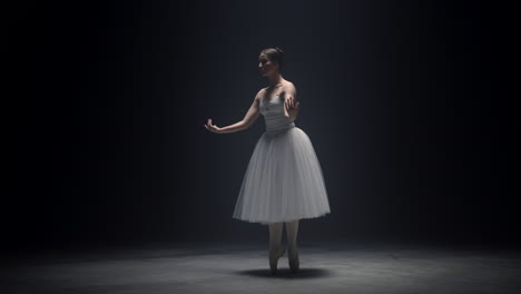 beautiful ballerina dancing on tiptoe indoors. ballet dancer rehearsing on stage