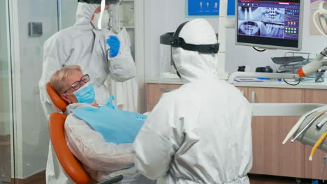 doctor in coverall showing dental hygiene using mock-up of skeleton