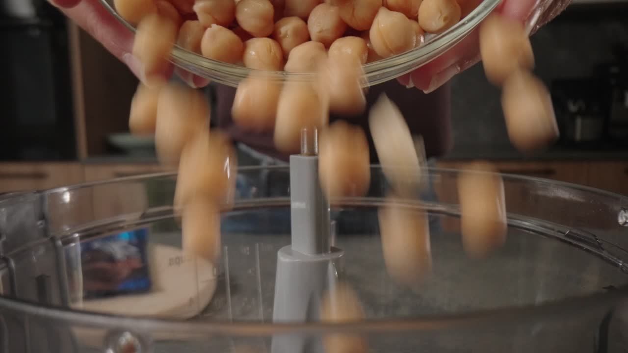 Vista macro di ceci versati in un frullatore per una ricetta a base vegetale