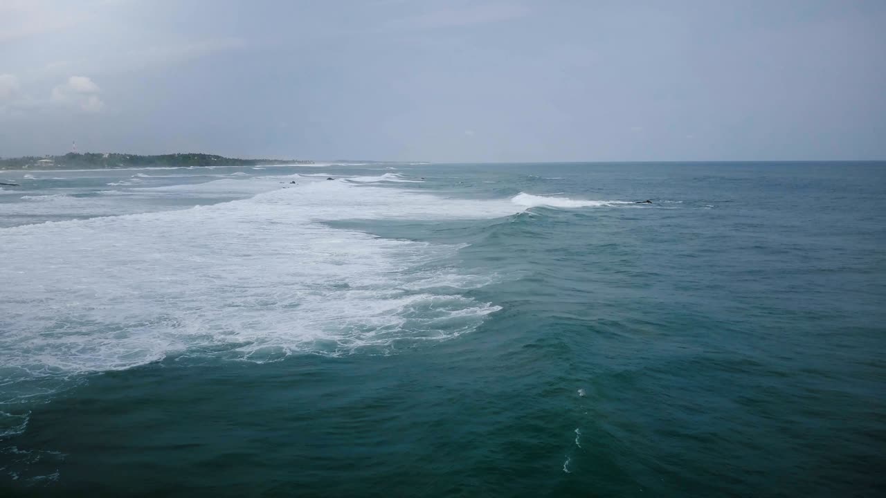 커다란 어두운 파란색 바다 파도가 카메라를 통과하고  거품으로 부히고, 구름이 많은 폭풍우 지평선의 공중 드론