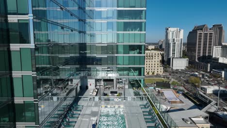piscina en el techo de un edificio moderno de gran altura con un fondo de paisaje urbano y un cielo azul claro