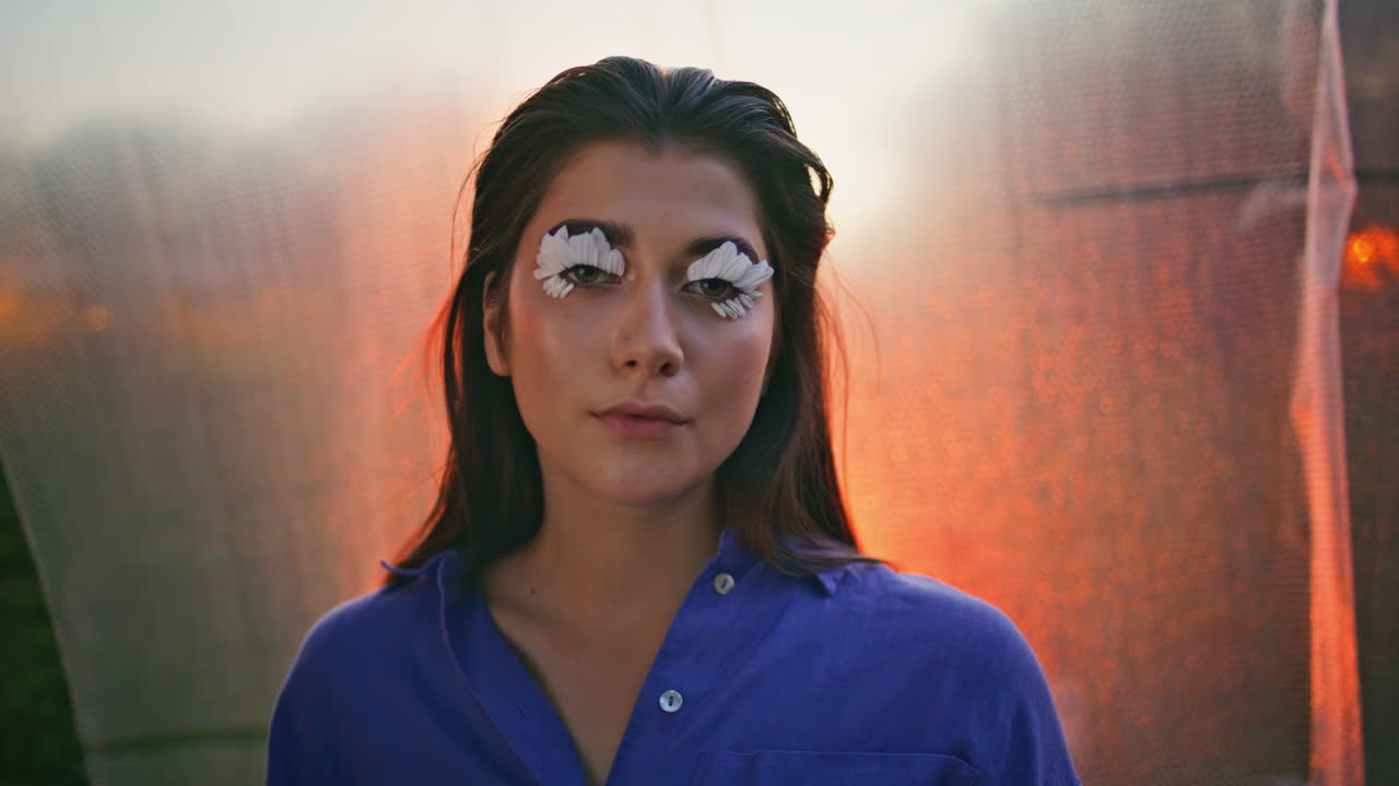 lady pétalos ojos maquillaje de pie sereno en el atardecer brillo primer plano. retrato mujer