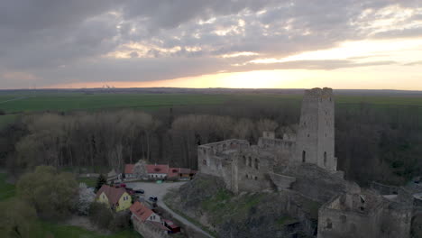 Ruined-medieval-castle-Okoř-in-Czechia-at-dusk,above-a-village,aerial