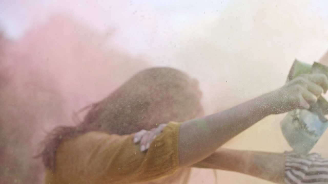 Amici che si divertono con le polveri Holi durante un festival musicale