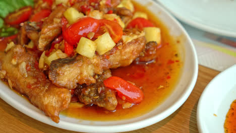 fried-grouper-fish-topped-with-sweet-,sour-and-hot-sauce-on-white-plate---Asian-food-style