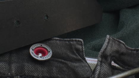 macro close up of a dark leather belt and a pair of jeans