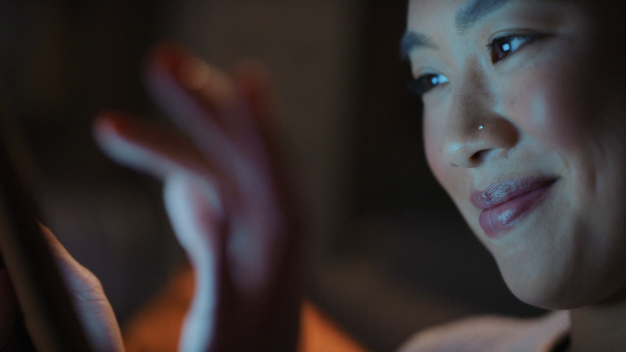 늦은 밤 집에서 디지털 태블릿 기술을 사용하는 아름다운 아시아 여성