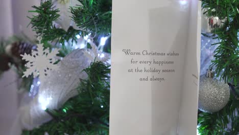 christmas card with message hanging on the tree