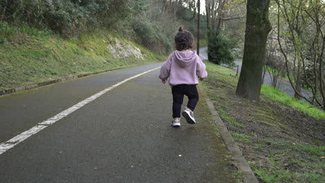 back view of toddler running, then laughing looking at camera