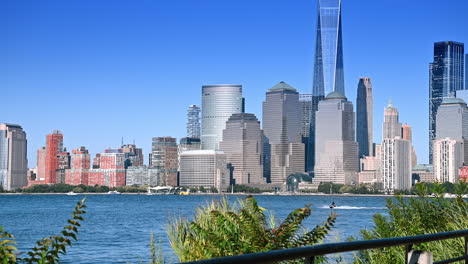 waterfront walk with skyline views. people stroll along the waterfront pathway enjoying the vibrant skyline in new york during a sunny day