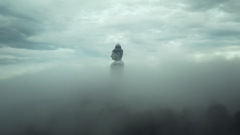 giant buddha statue in foggy mountains