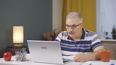 Home office worker old man working seriously and focused.