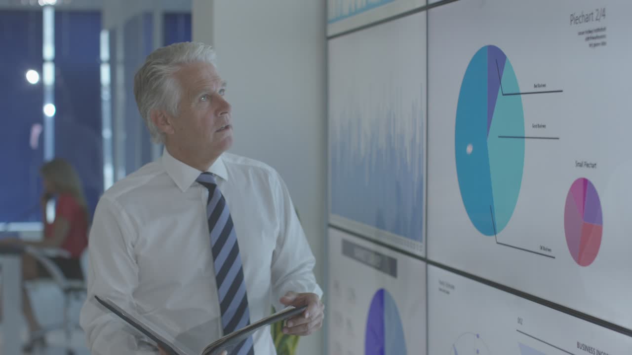 reunión de empresarios en la sala de juntas con referencia a los datos de la hoja de cálculo en la pantalla grande