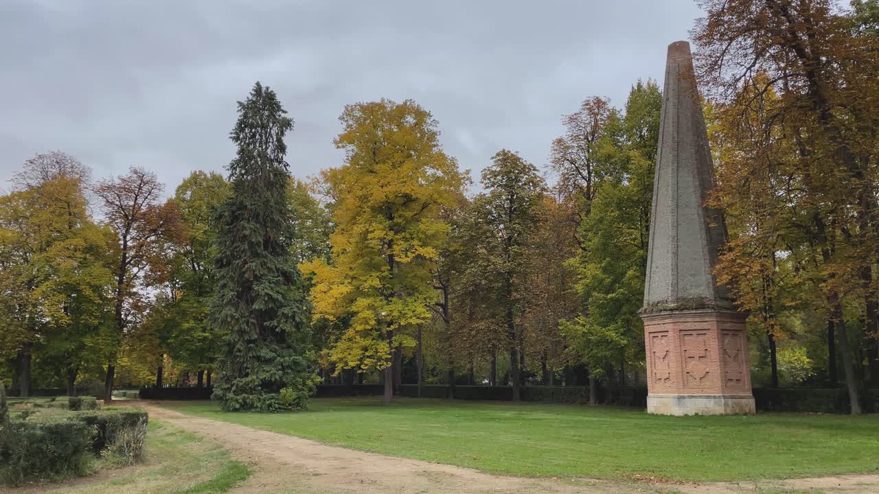 Immagini catturate con una telecamera a scansione laterale, focalizzate su un obelisco nei Giardini Reali di Aranjuez. I grandi alberi che lo circondano sfoggiano i colori autunnali, valorizzando il paesaggio e il suo contesto storico.