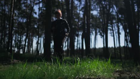 una mujer con ropa de correr corriendo a través de un bosque soleado de la mañana