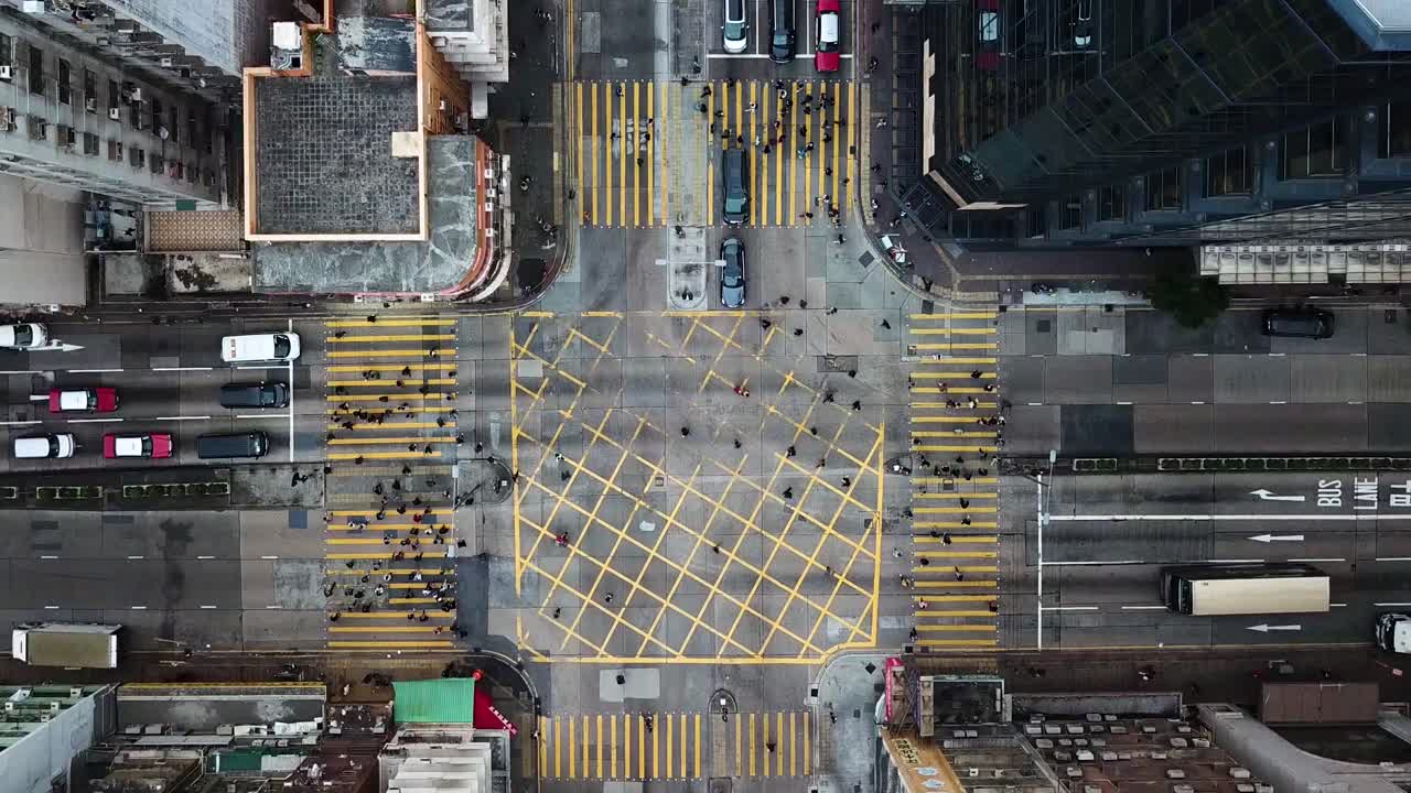 Aerial view of pedestrians crossing the roads along four zebra crossing in Kowloon, Hong Kong.