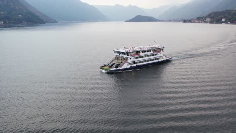 ferry boat carrying cars sailing across the lake como to bellagio comune in italy
