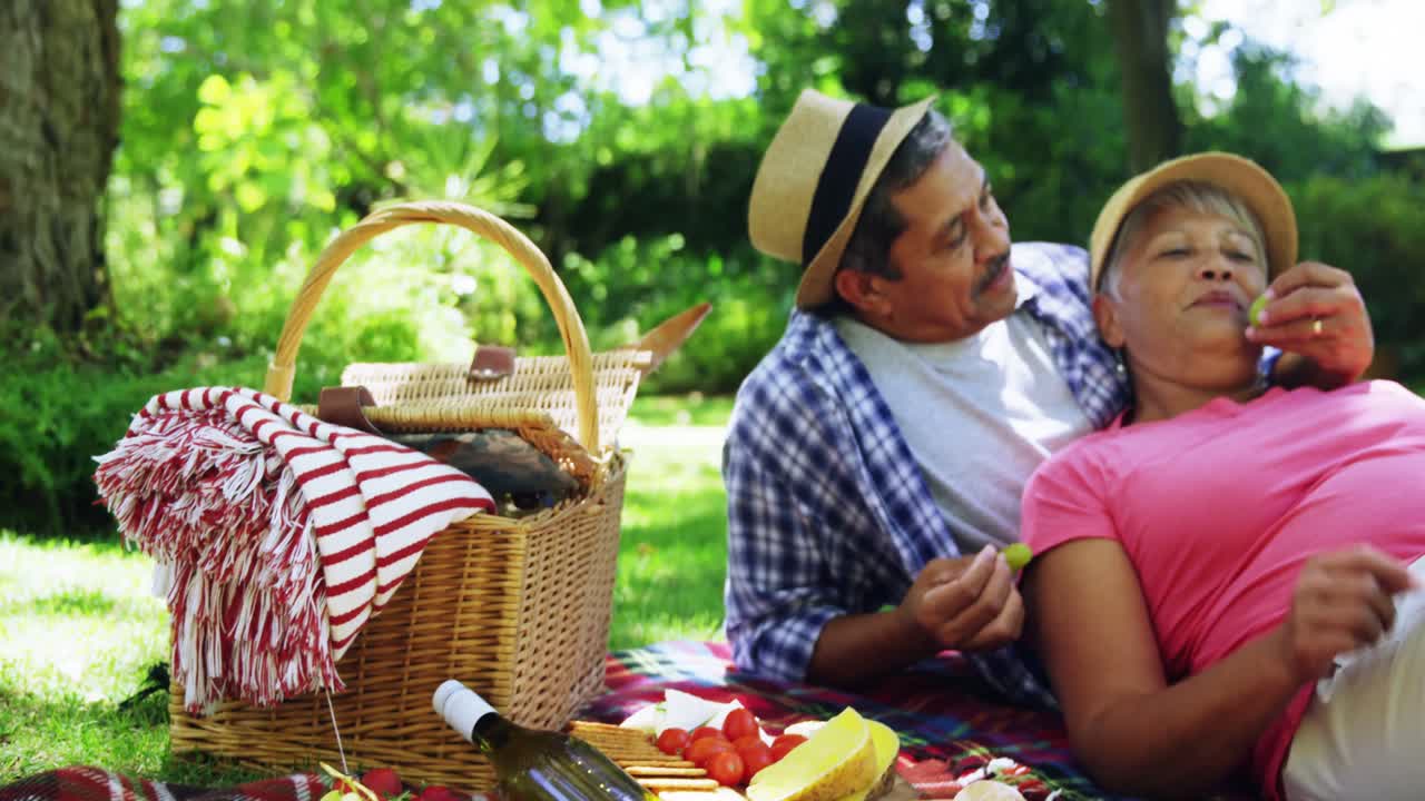 고위 부부 가 서로 포도 를 먹이는 것