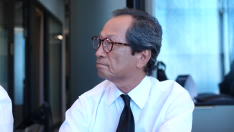 a japanese businessman is listening to a presentation during a business meeting