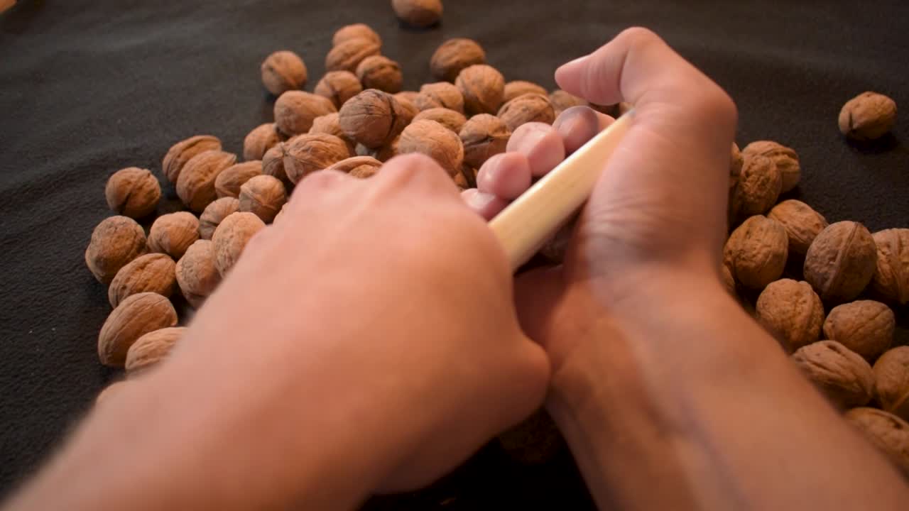 Young man is cracking some fresh dried walnuts-7