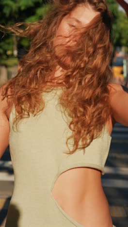 woman with curly hair in a green tank top