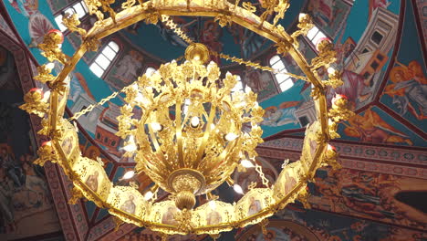 großer goldener kronleuchter in einer wunderschönen bemalten orthodoxen kirche