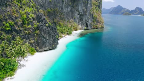 imágenes de vuelo aéreo de drones de la prístina playa de arena blanca tropical rodeada de acantilados rocosos cársticos y mar turquesa. isla pinagbuyutan. el nido, palawan, filipinas. destino impresionante