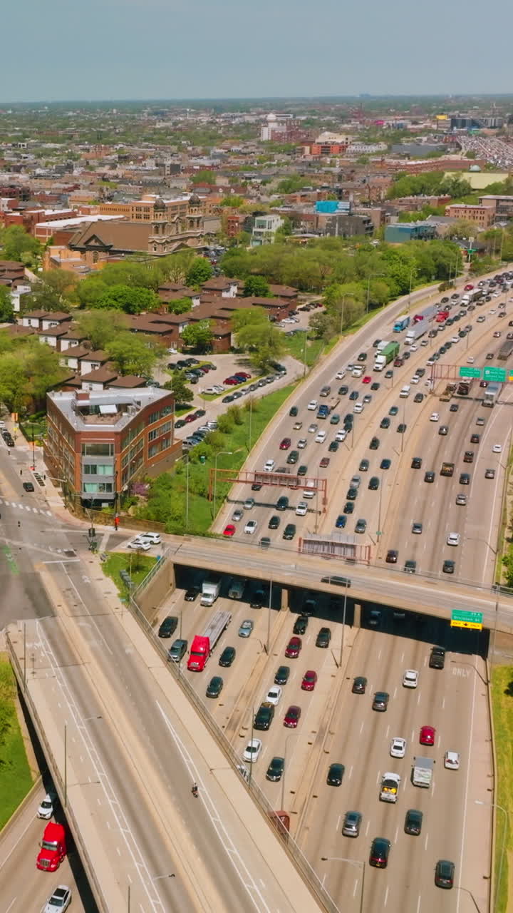 Wide multiple-lane roads with numerous cars. Automobiles driving in both directions on the busy roads. Vertical video