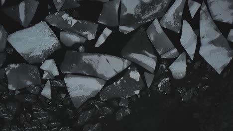 drone shot flying over frozen lake covered in ice chunks and snow chunks