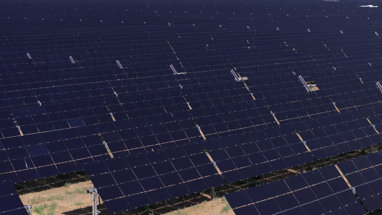 Large field of solar panels capturing sunlight for renewable energy, aerial view