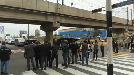 a police motorcade drives by a group of reporters and cameramen and some police officers, as a part of the apec 2024 summit in lima, peru.