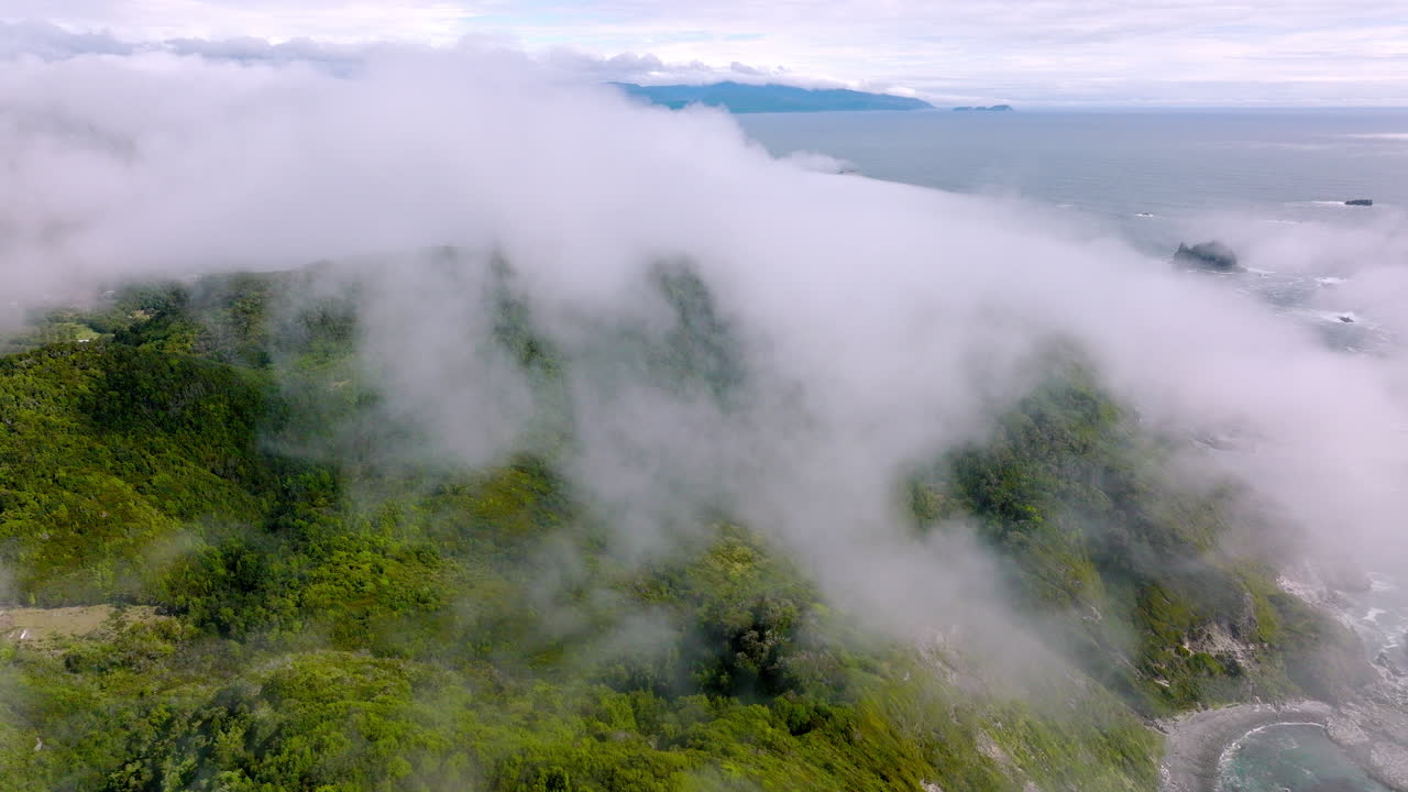drone volando sobre las nubes revelando la pintoresca costa de la isla de chiloé