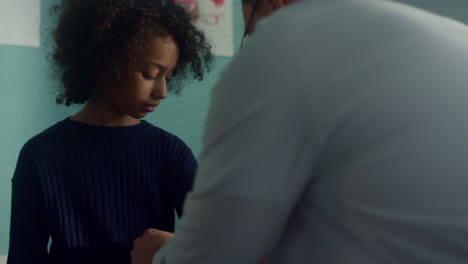 Doctor-using-tonometer-cuff-on-kid-arm.-Teen-girl-medical-examination-close-up.