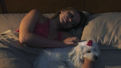 woman stroking dog in bed sleeping at night